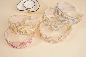 Detailed embroidery on bohemian headbands with sequins and mesh fabric displayed flatly