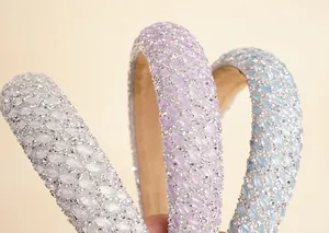 Detailed view of three thick rhinestone headbands in silver, violet, and light blue