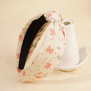Blumen-Knoten-Haarband mit Vintage-Muster und schwarzem Futter auf einer Keramikvase