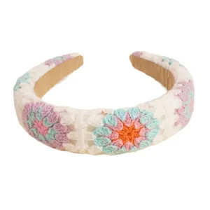 Handmade crochet sunflower headband with colorful floral knit pattern on cream base