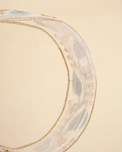 Macro detail of Bohemian leaf embroidery on white organza headband with gold wire edges