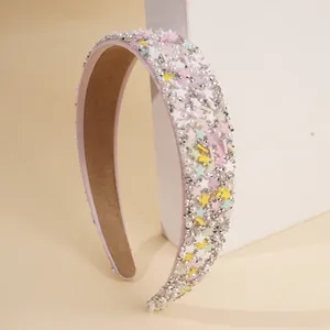 Detailaufnahme von rosa Haarreif mit Sternpailletten, Perlen und funkelnden Strasssteinen