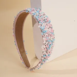 Nahaufnahme eines pastellfarbenen Haarreifs mit Blumen, Perlen und Glitzersteinen