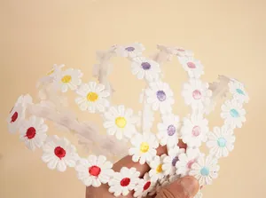 Detail view of colorful daisy embroidery on white lace headbands with non-slip teeth