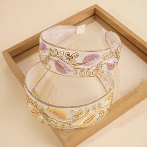 Detail of embroidered bohemian headband with gold threads and sequins on organza fabric