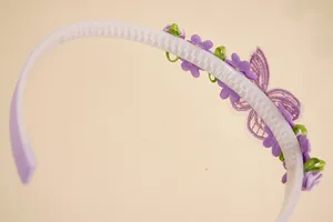 Detail of purple hairband showing non-slip teeth and butterfly embroidery texture