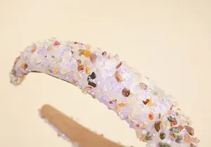 Détail macro du serre-tête baroque avec pierres colorées et paillettes sur velours