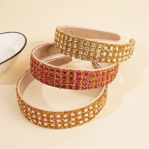 Close-up of three sparkling rhinestone headbands in white, rose, and light pink colors