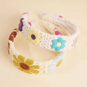 Detailansicht des handgefertigten Häkel-Stirnbands mit weißer Stricktextur und bunten Blumen