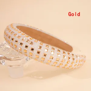 Detail of the golden thick sponge headband with four rows of square rhinestones on a shiny base