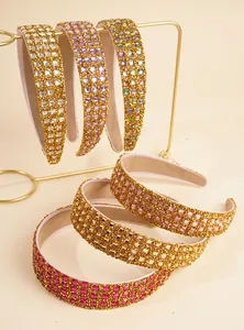 Detail of luxury wide headbands featuring colorful square rhinestones and gold glitter base