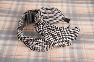 Détail de deux serre-têtes larges à motif pied-de-poule noir et blanc avec nœud en tissu
