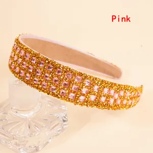 Detail of pink crystal rhinestones on wide headband draped over a glass bottle