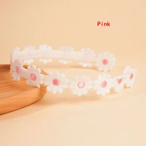 Close-up of pink flower embroidery and texture on a white daisy headband for women