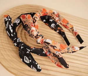 Detail von Halloween-Stirnbändern mit Fledermaus- und Kürbismustern auf Holztablett