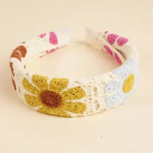 Detailansicht des handgefertigten Boho-Häkelstirnbandes mit bunten gestrickten Blumenmustern