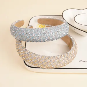 Sparkling rhinestone sponge headbands in light blue and yellow colors on a white plate