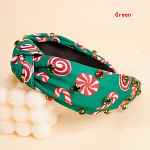 Close-up of green Christmas knot headband with candy cane prints and rhinestones