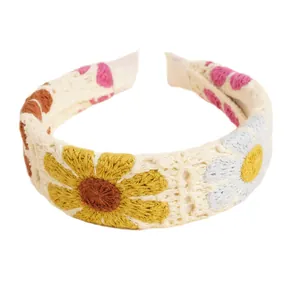 Böhmisches Häkelstirnband mit bunten Strickblumen und Herzmustern auf weißer Basis