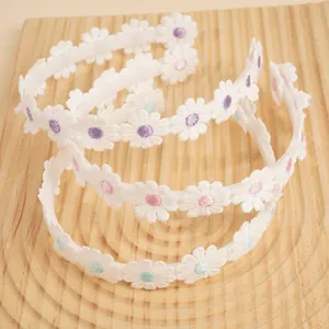 Three-piece set of white embroidered daisy headbands with purple and pink floral details