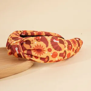 Détail du bandeau noué de Thanksgiving avec motifs dinde et citrouille sur plateau en bois