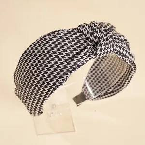 Détail d'un serre-tête large à motif pied-de-poule avec un nœud élégant sur le dessus