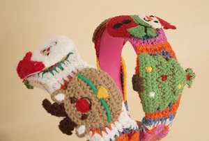 Close-up of handmade crochet Christmas headbands with 3D Santa and snowman details