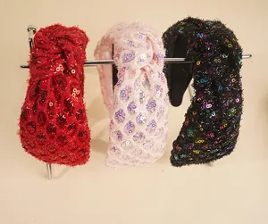 Detailed view of sequined fabric headbands in red, pink, and black with a knot design