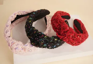 Detail of sequin fabric headbands with twist knot in pink, black, and red colors