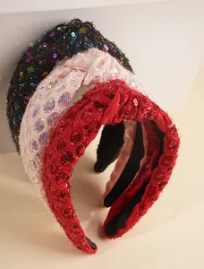 Macro shot of stylish knotted headbands with shimmering sequins in black, pink, and red