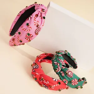 Close-up of three festive knotted headbands with candy cane prints and sparkling rhinestones