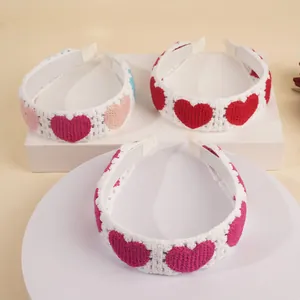 Vue détaillée de trois serre-têtes en tricot fait main avec cœurs en crochet colorés