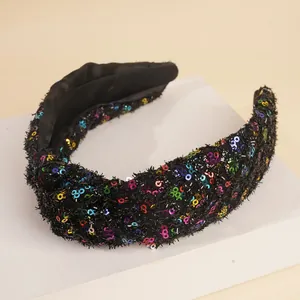 Detail of black fabric headband featuring colorful sequins and a stylish knot design