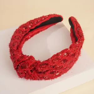 Detail of red sequin twisted headband with feather tassels and non-slip inner lining