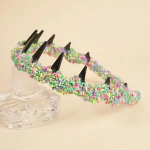Makro-Detail eines bunten Stachelstirnbands mit bonbonfarbenen Perlen und Punk-Stacheln