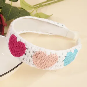Détail d'un bandeau au crochet fait main avec motifs de cœurs et texture en tricot