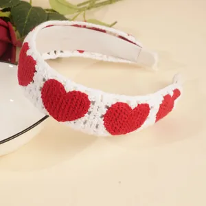 Détail d'un serre-tête blanc au crochet avec motifs de cœurs rouges et tricot doux