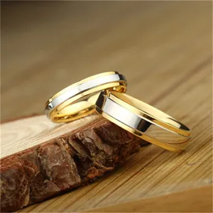 Minimalist two-tone tungsten steel rings with stepped edges on a natural wood block