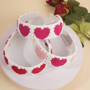 Trois serre-têtes en tricot fait main avec motifs de cœurs au crochet sur présentoir