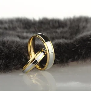 Minimalist tungsten steel couple rings with gold stepped edges on plush background