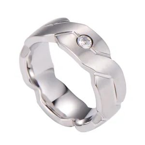 Macro view of brushed tungsten steel ring with wave geometry and centered diamond accent