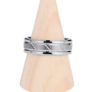 Dettaglio dell'anello in tungsteno spazzolato con texture geometriche su supporto