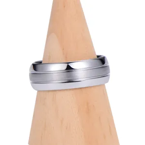 Bague en acier tungstène brossé et poli présentée sur un support en bois conique