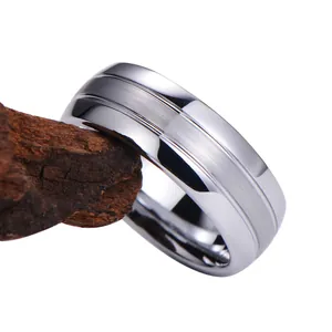 Bague en acier de tungstène minimaliste avec texture brossée et bords polis sur bois