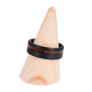 Black brushed tungsten ring with deep brown wood grain inlay on wooden display