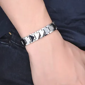 Close-up of men's tungsten steel bracelet with geometric links on denim background