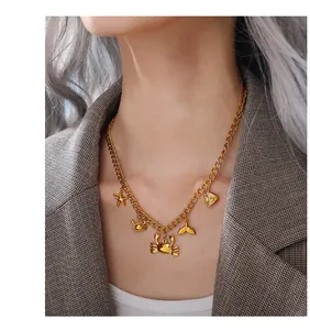 Detailed view of a gold ocean-themed necklace with starfish and crab charms on a model