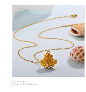 Detail showing the gold shell pendant with pearls and small starfish on a thin chain