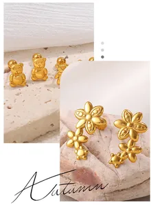 Dettagli macro di orecchini a forma di orso dorato e fiori testurizzati su pietra