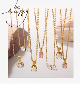 Detail view of 18K gold plated necklaces with opal and zircon pendants on pink stone